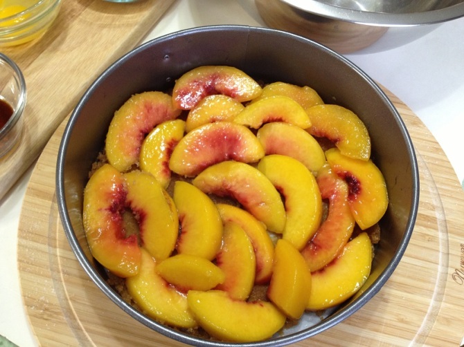 arranging peaches in uniform over brown sugar mixture
