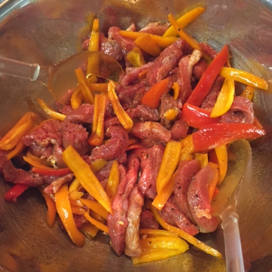 adding meat and peppers to oil spice mix