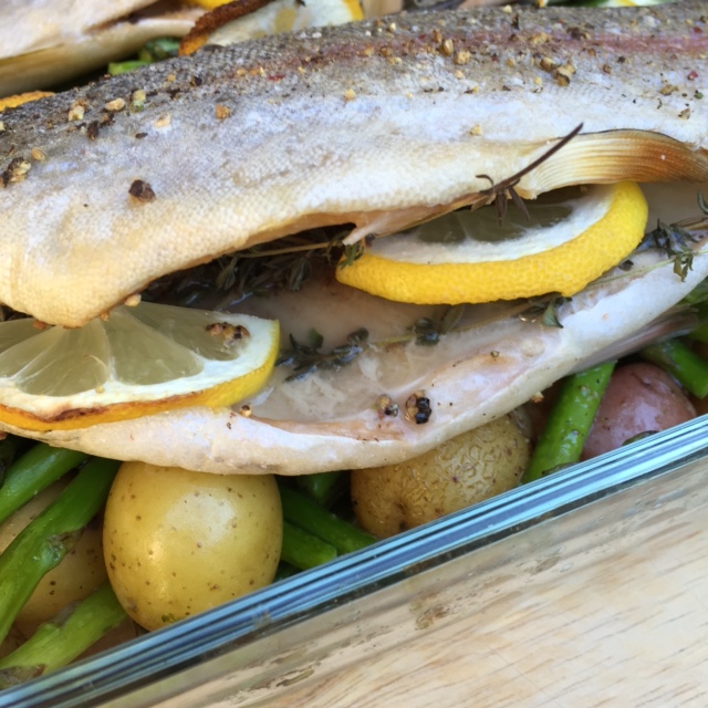 Fresh roasted trout showing the amazing flavors of freh thyme, cruched pepper corns and lemon slices